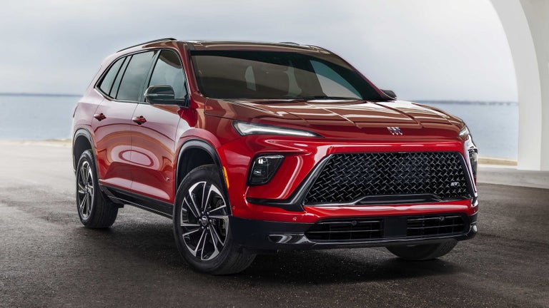 Three Quarters Rear View of a Red 2025 Buick Enclave Under a Bridge