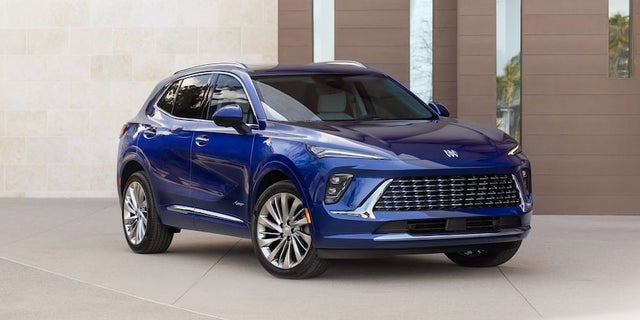 Wide Front Three-Quarters View of the 2024 Buick Envision Small SUV Parked In Front of a Building