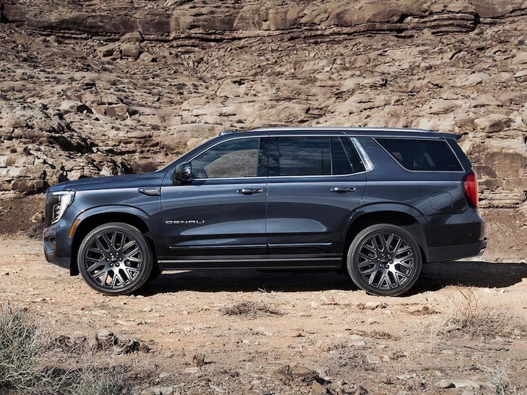 Profile View of the GMC Yukon Large SUV Parked in the Desert on Rough Terrain